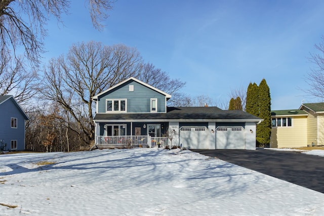 traditional-style house featuring aphalt driveway, a porch, and an attached garage