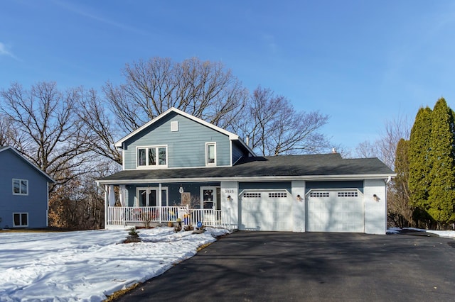 traditional-style home with a porch, driveway, and an attached garage