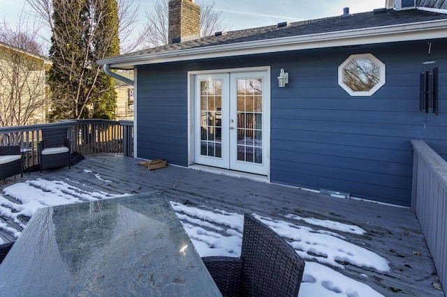 snow covered deck with french doors