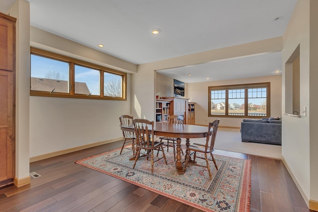 dining space featuring recessed lighting, a fireplace, baseboards, and wood finished floors