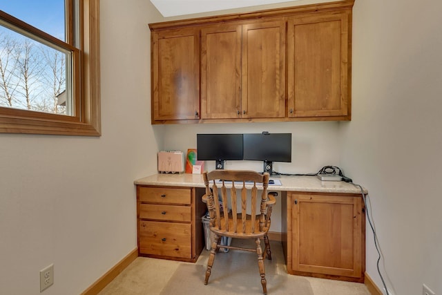 home office with built in study area and baseboards