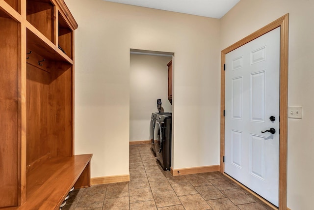 mudroom featuring light tile patterned floors, baseboards, and separate washer and dryer