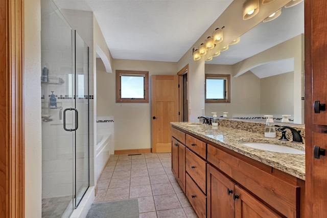 bathroom featuring tile patterned flooring, a shower stall, a garden tub, and a sink