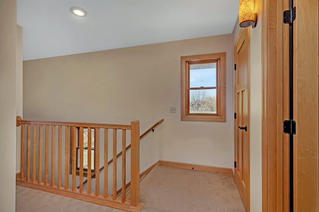 hallway with carpet, an upstairs landing, and baseboards