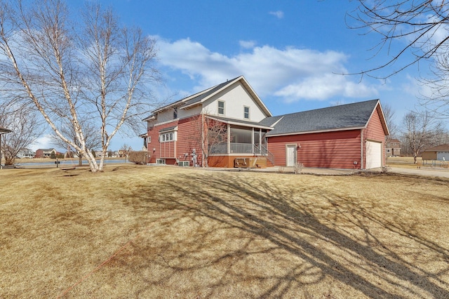 view of front of property with a front yard, a garage, and a sunroom