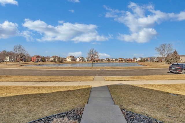 view of yard featuring a residential view and a water view