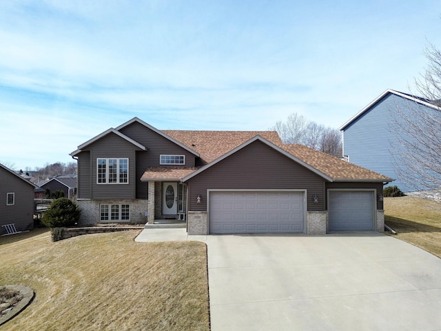 split level home featuring a garage, driveway, brick siding, and a front lawn