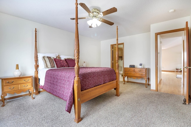 carpeted bedroom with a ceiling fan, baseboards, and a textured ceiling