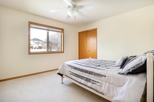 bedroom featuring baseboards, a textured ceiling, a ceiling fan, and carpet