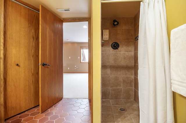 full bath featuring tile patterned floors, visible vents, and a tile shower