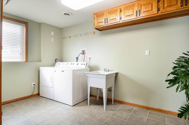 clothes washing area featuring visible vents, cabinet space, washing machine and dryer, and light tile patterned flooring