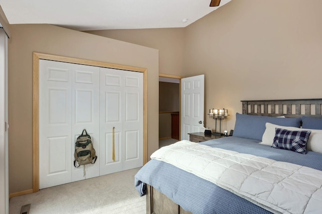 carpeted bedroom with a closet, a ceiling fan, and vaulted ceiling