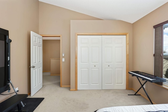 bedroom featuring vaulted ceiling, light colored carpet, a closet, and baseboards