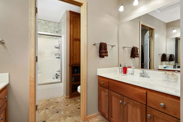 bathroom featuring toilet, vanity, and bath / shower combo with glass door