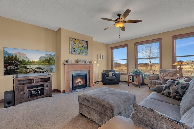 living room with a tiled fireplace, carpet flooring, plenty of natural light, and a textured ceiling