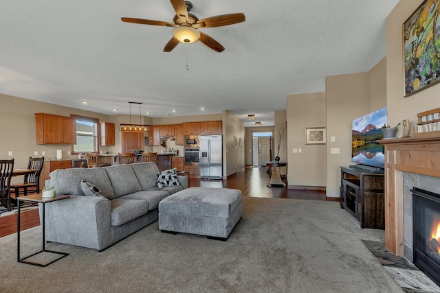 living area featuring dark wood finished floors, recessed lighting, a fireplace, and a textured ceiling