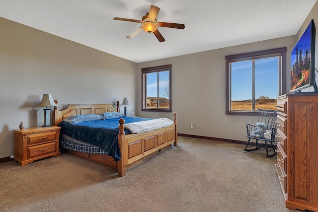 carpeted bedroom featuring a textured ceiling, a ceiling fan, and baseboards