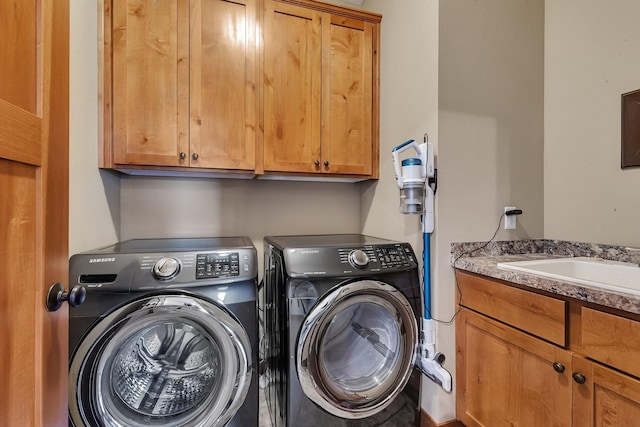 laundry room featuring a sink, cabinet space, and separate washer and dryer