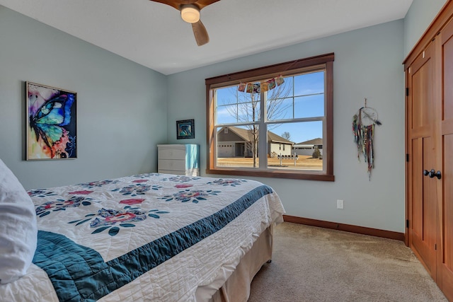 carpeted bedroom featuring baseboards and ceiling fan