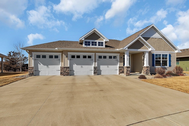 craftsman-style house featuring a garage, stone siding, and concrete driveway