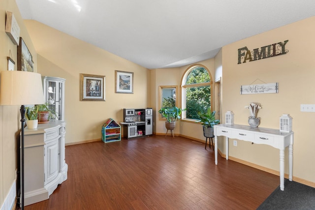 living area with baseboards, lofted ceiling, and dark wood-style flooring