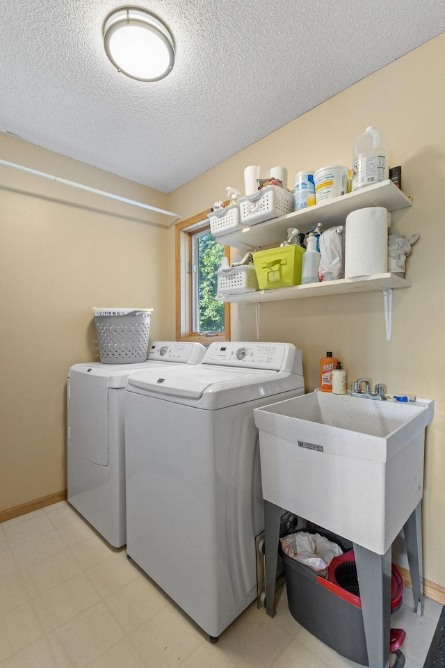 laundry area featuring laundry area, baseboards, independent washer and dryer, and a textured ceiling