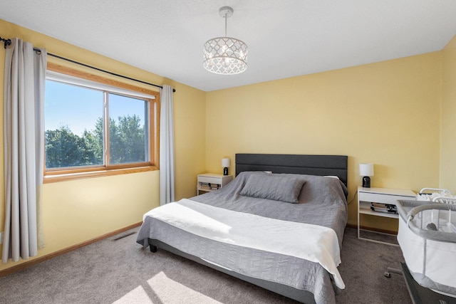 bedroom with a notable chandelier, carpet flooring, visible vents, and baseboards