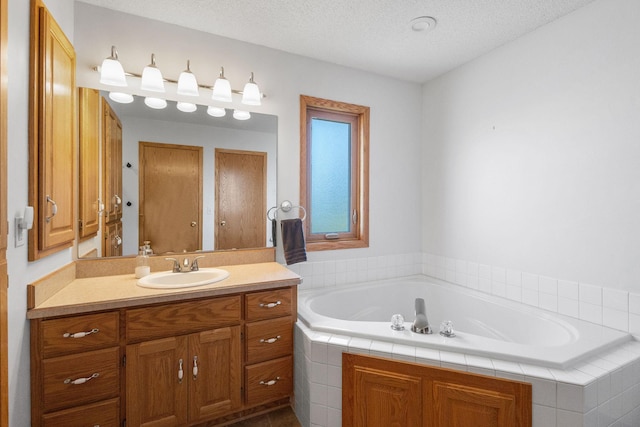 bathroom featuring a bath, a textured ceiling, and vanity