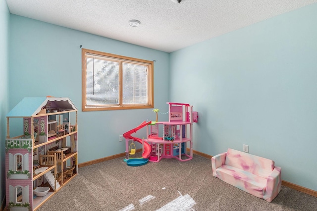 playroom with baseboards, carpet, and a textured ceiling