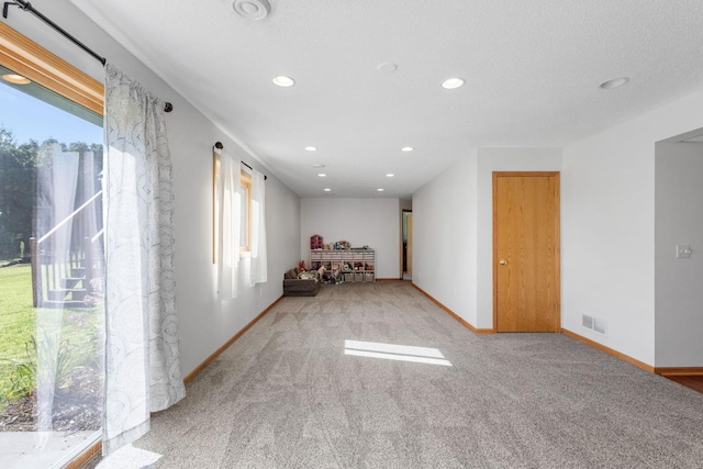 carpeted empty room with visible vents, recessed lighting, and baseboards