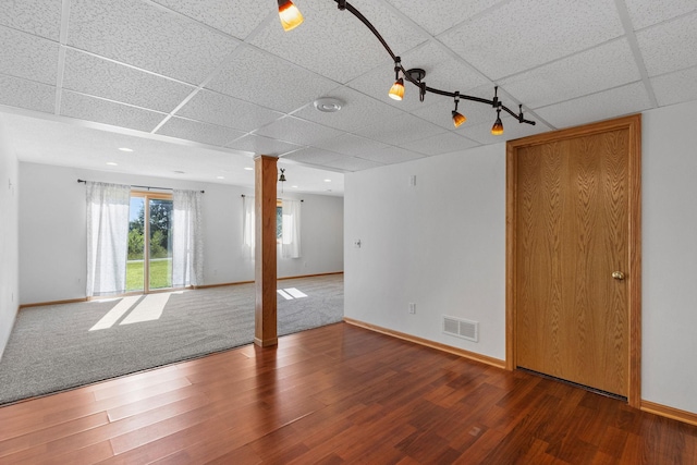 spare room with visible vents, a paneled ceiling, wood finished floors, and ornate columns