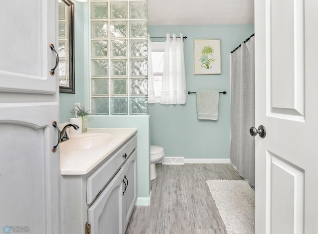 full bathroom featuring visible vents, toilet, wood finished floors, baseboards, and vanity