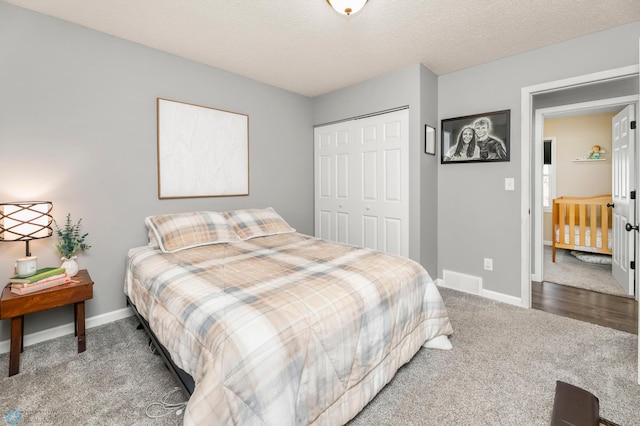 carpeted bedroom with a closet, visible vents, a textured ceiling, and baseboards