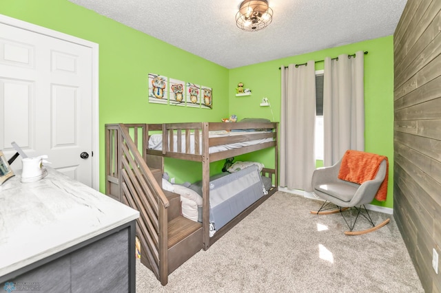 bedroom with a textured ceiling and wooden walls