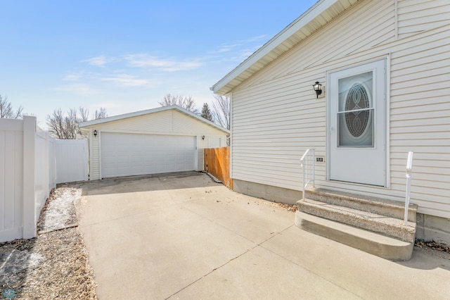 property entrance featuring a detached garage and fence