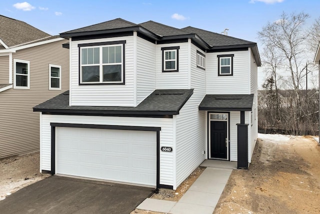 view of front of property with an attached garage, driveway, and a shingled roof