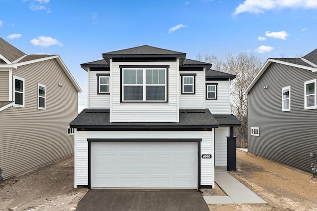 view of front of property featuring a garage, roof with shingles, and driveway