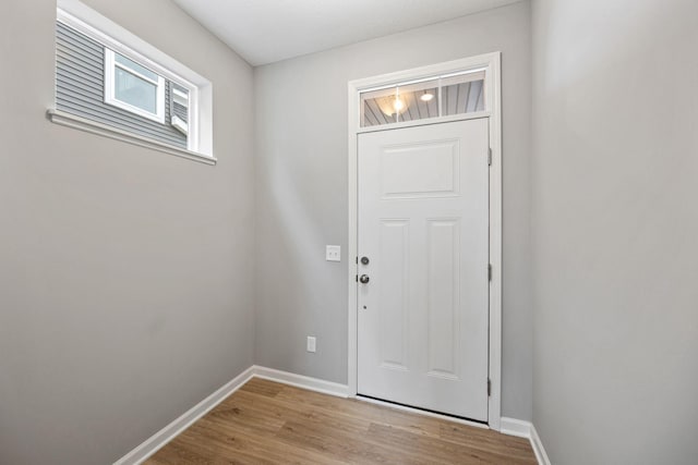 doorway to outside with baseboards and light wood finished floors