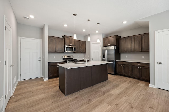 kitchen featuring light wood finished floors, dark brown cabinets, light countertops, stainless steel appliances, and a sink