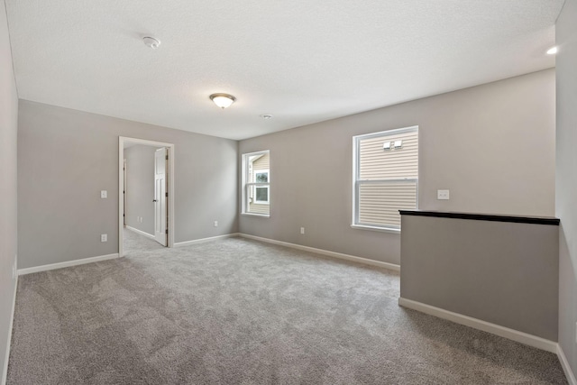 unfurnished room with baseboards, a textured ceiling, and carpet flooring