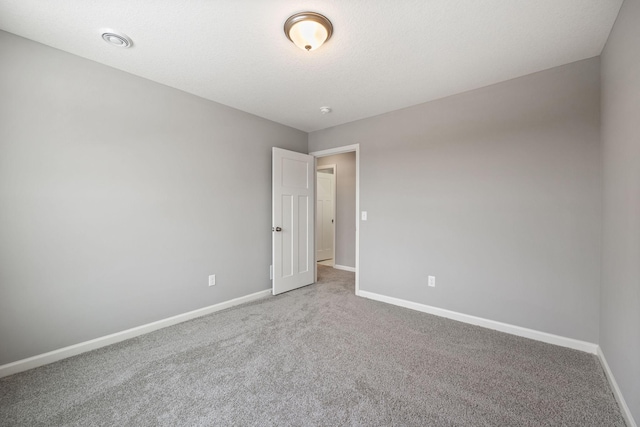 empty room with visible vents, carpet, and baseboards