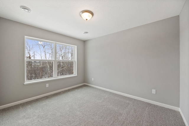 empty room featuring baseboards and carpet floors