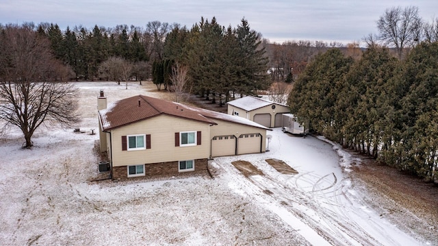 snowy aerial view with a wooded view