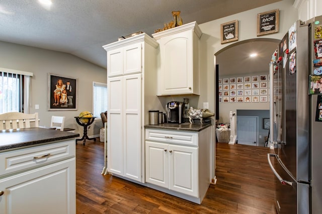 kitchen with dark wood finished floors, dark countertops, a wealth of natural light, and freestanding refrigerator