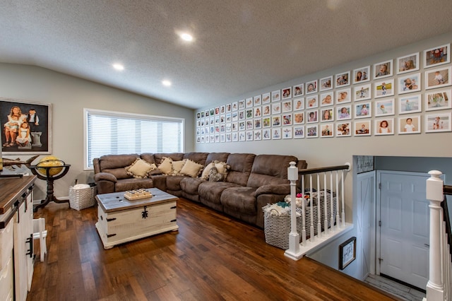 living room with dark wood finished floors, a textured ceiling, and vaulted ceiling