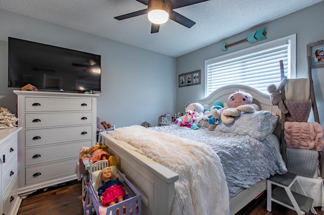 bedroom featuring dark wood finished floors, ceiling fan, and a textured ceiling