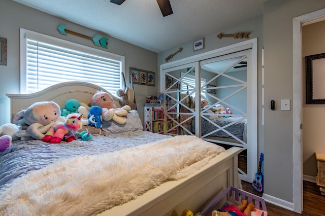 bedroom featuring a textured ceiling, a ceiling fan, baseboards, and wood finished floors