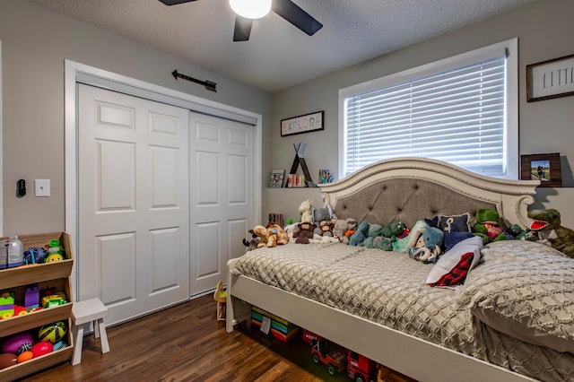 bedroom featuring a closet, a textured ceiling, dark wood-style floors, and a ceiling fan