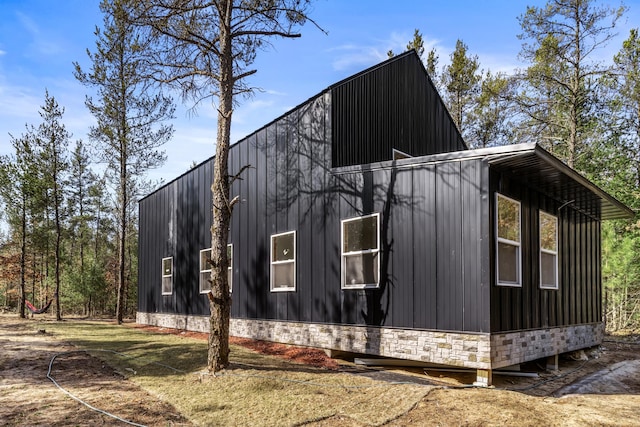 view of property exterior with board and batten siding and stone siding