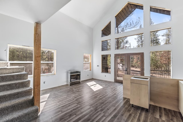 living area with dark wood-style floors, high vaulted ceiling, stairway, and french doors